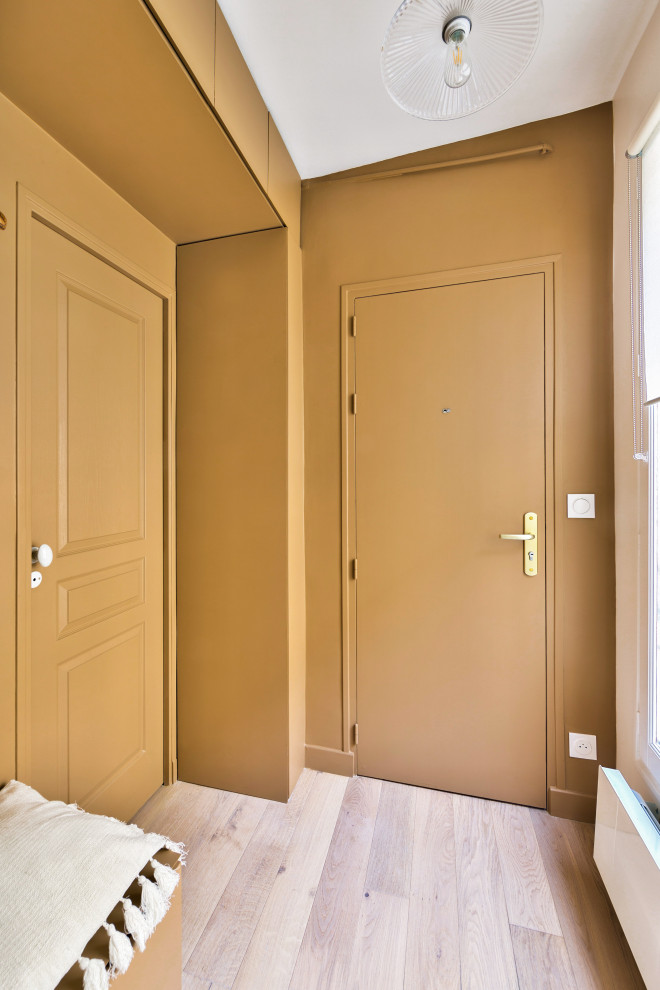 Ejemplo de vestíbulo contemporáneo de tamaño medio con paredes marrones, suelo de madera clara, puerta simple y puerta marrón