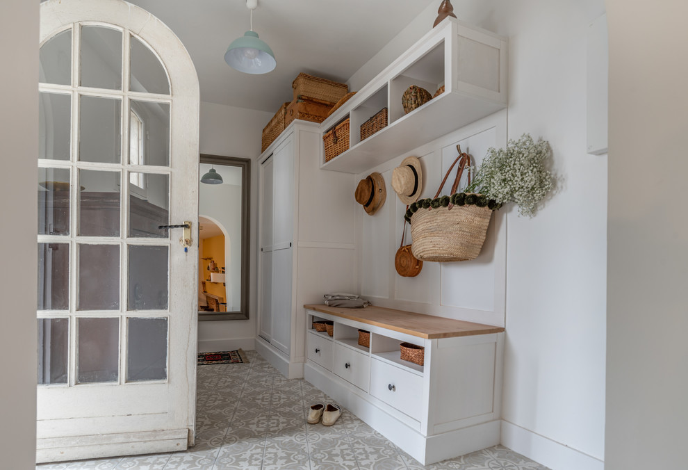 Exemple d'une entrée chic de taille moyenne avec un couloir, un mur blanc, un sol en carrelage de céramique, une porte simple, une porte en verre et un sol gris.