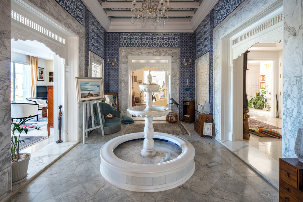 Idées déco pour une grande entrée méditerranéenne avec un mur bleu et un sol en marbre.