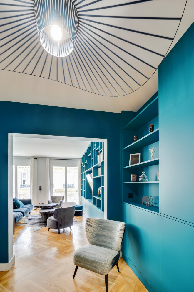 パリにある高級な広いコンテンポラリースタイルのおしゃれな玄関ロビー (青い壁、淡色無垢フローリング、白いドア、ベージュの床) の写真