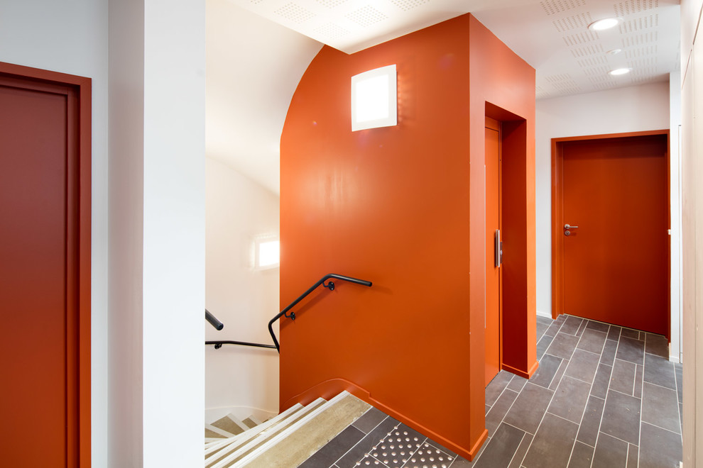 Idéer för stora funkis foajéer, med orange väggar, klinkergolv i keramik, en dubbeldörr och en vit dörr