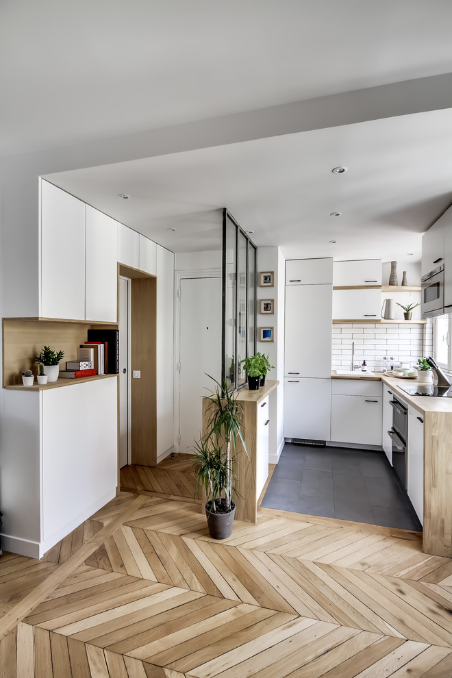 Mittelgroße Nordische Haustür mit weißer Wandfarbe, braunem Holzboden, Einzeltür, weißer Haustür und braunem Boden in Paris