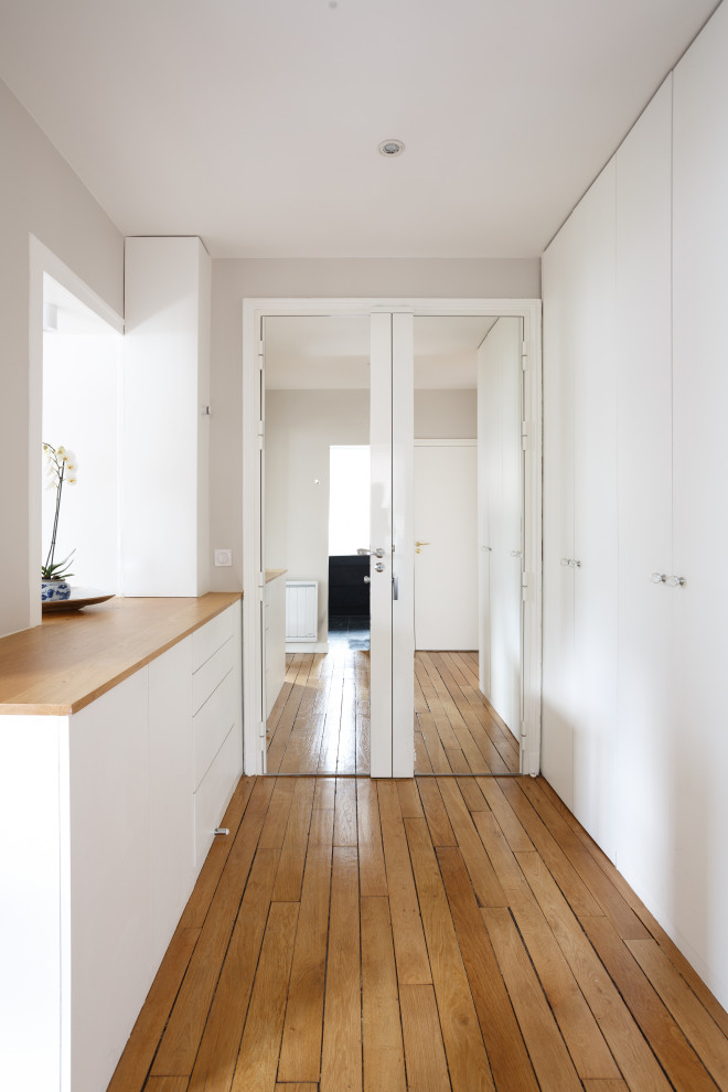 Exempel på en mellanstor klassisk foajé, med grå väggar, mellanmörkt trägolv, en dubbeldörr, en vit dörr och brunt golv