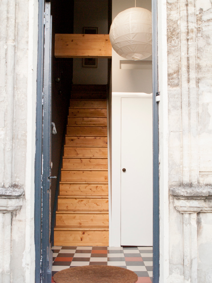 Idee per un ingresso minimal di medie dimensioni con pareti bianche, pavimento con piastrelle in ceramica, una porta a due ante, una porta blu e armadio