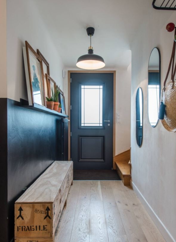 Kleiner Eklektischer Eingang mit Korridor, schwarzer Wandfarbe, hellem Holzboden, Einzeltür und schwarzer Haustür in Nantes