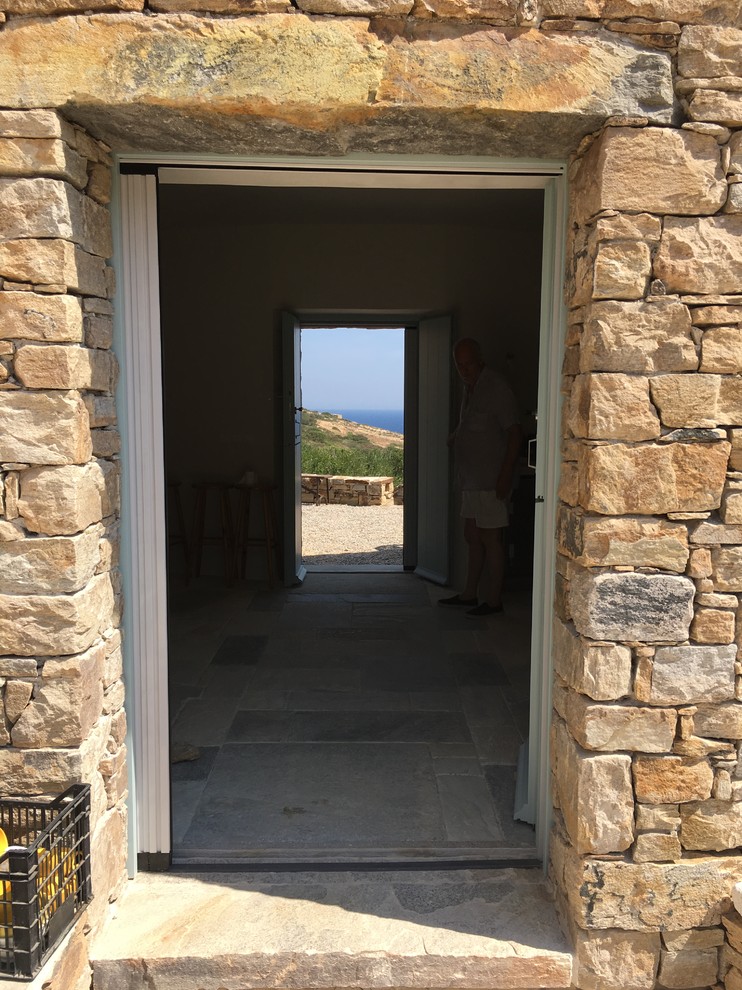 Réalisation d'une grande porte d'entrée méditerranéenne avec un mur beige, un sol en marbre, une porte double, une porte verte et un sol beige.