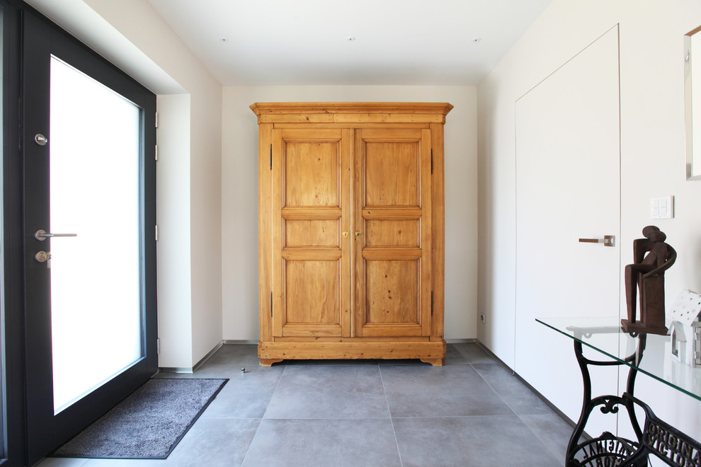 Aménagement d'un vestibule rétro de taille moyenne avec un mur blanc, un sol en carrelage de céramique, une porte simple et une porte en bois foncé.