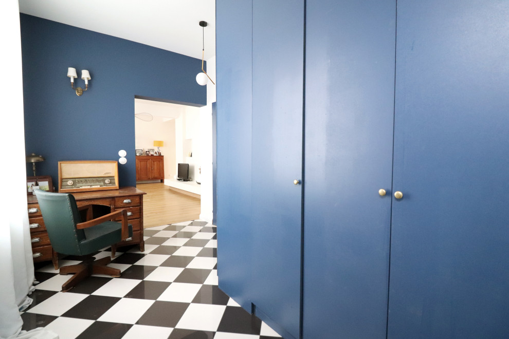 Imagen de vestíbulo minimalista de tamaño medio con paredes azules, suelo de baldosas de cerámica y suelo negro