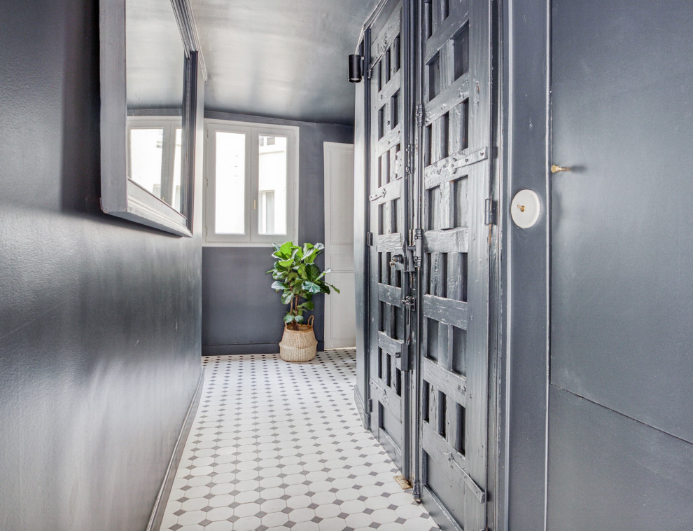 Idée de décoration pour une petite entrée tradition avec un couloir, un mur bleu, un sol en carrelage de céramique, une porte double, une porte en bois foncé et un sol blanc.