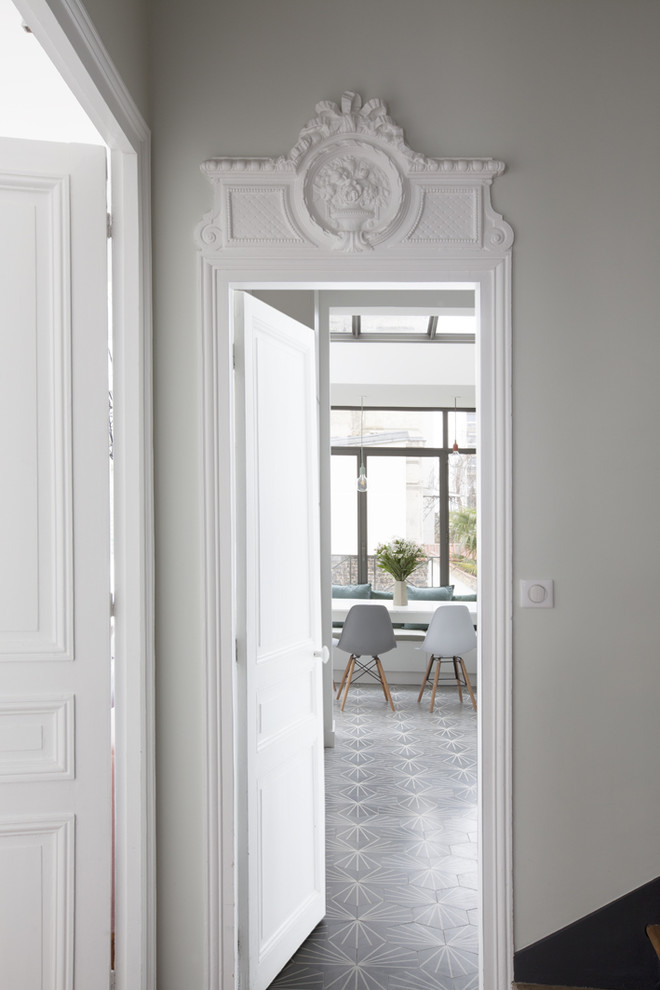 Idées déco pour un hall d'entrée contemporain avec un mur gris, une porte blanche et un sol gris.