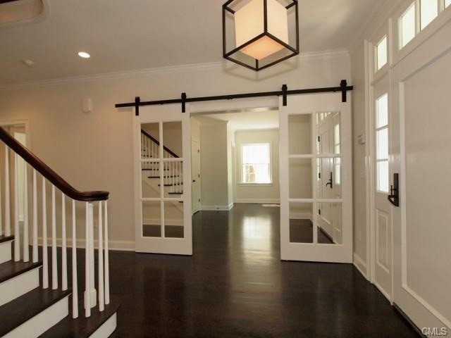 Entryway - large traditional dark wood floor entryway idea with white walls and a black front door