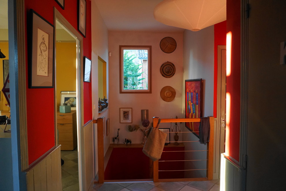 Ispirazione per un ingresso chic di medie dimensioni con pareti rosse, pavimento con piastrelle in ceramica e pavimento grigio