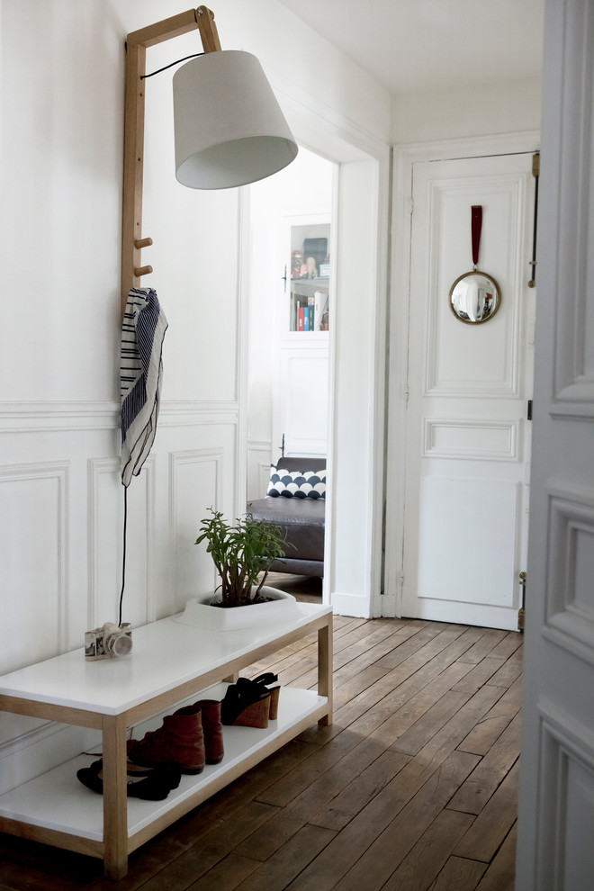 Inspiration pour une entrée design de taille moyenne avec un mur blanc et un sol en bois brun.