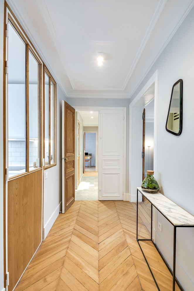 Mittelgroßes Klassisches Foyer mit grauer Wandfarbe, hellem Holzboden, Doppeltür und weißer Haustür in Paris