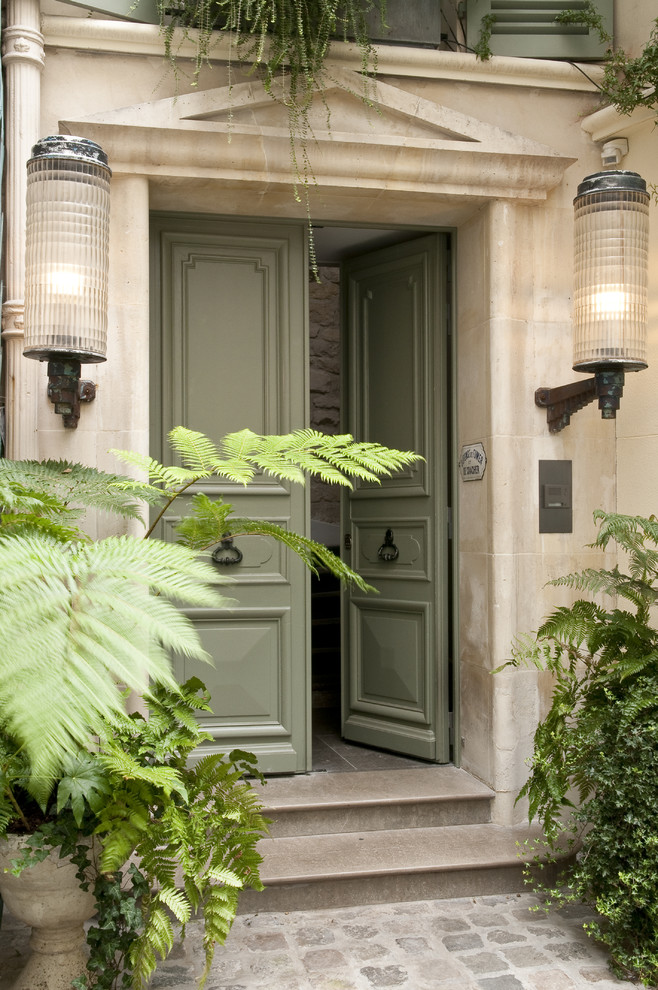 Immagine di una porta d'ingresso bohémian di medie dimensioni con pareti beige, una porta a due ante e una porta verde