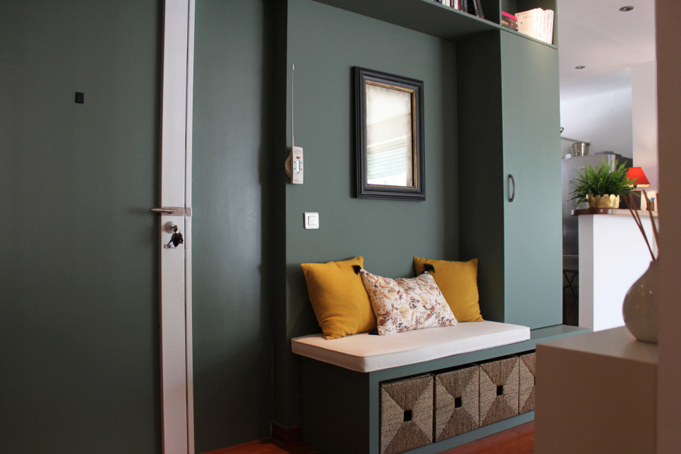 Bild på en stor funkis foajé, med gröna väggar, mörkt trägolv, en dubbeldörr, en grön dörr och orange golv