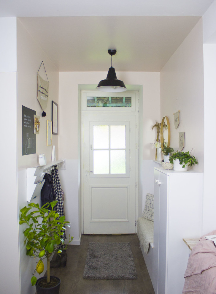 他の地域にある低価格の小さな北欧スタイルのおしゃれな玄関ロビー (ピンクの壁、濃色無垢フローリング、白いドア) の写真
