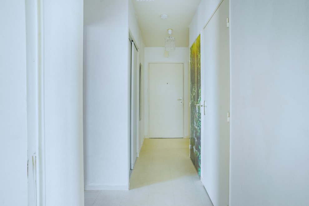 他の地域にある低価格の小さなエクレクティックスタイルのおしゃれな玄関ホール (白い壁、クッションフロア、白いドア、ベージュの床) の写真
