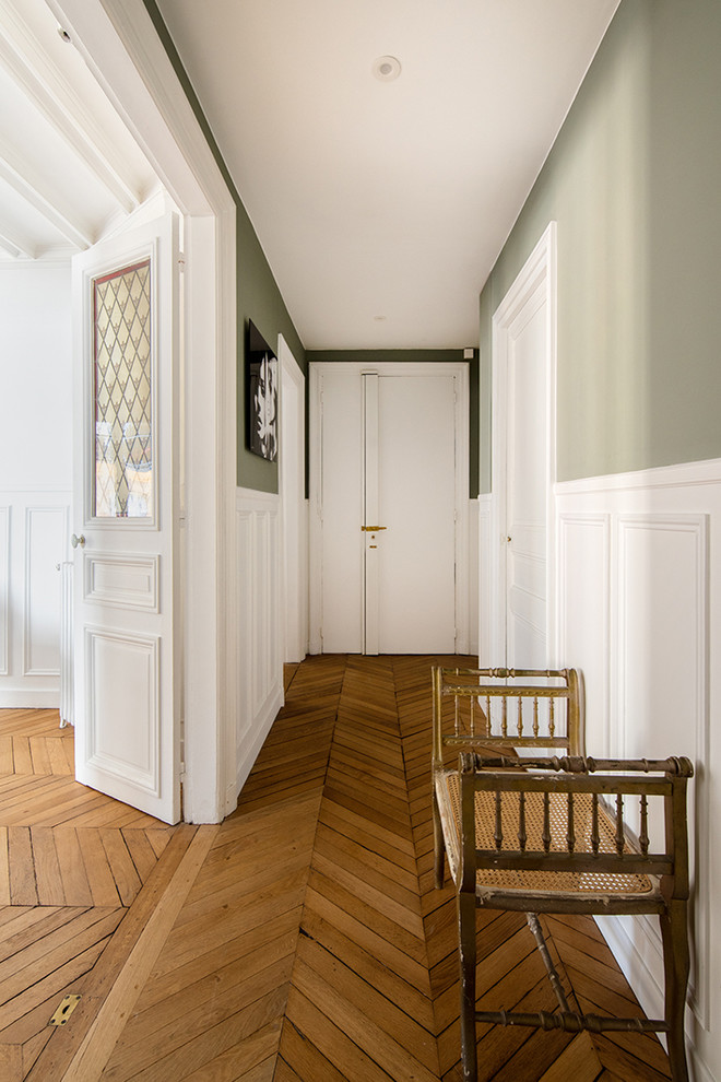 Imagen de hall tradicional renovado con paredes verdes, suelo de madera en tonos medios, puerta simple, puerta blanca y suelo marrón