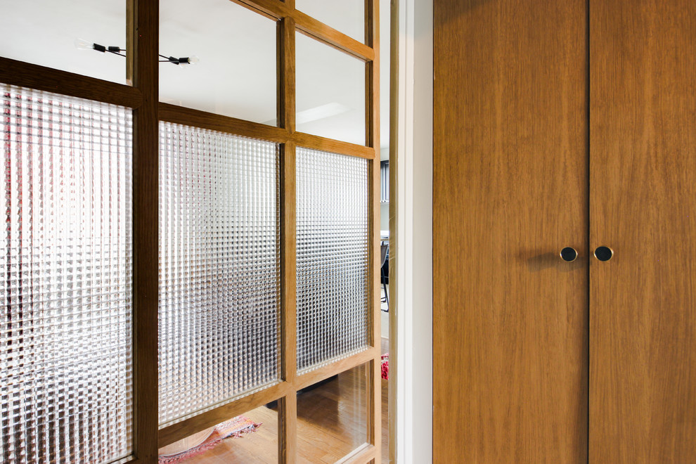 Inspiration pour un petit hall d'entrée avec un mur vert, une porte coulissante et une porte en bois clair.