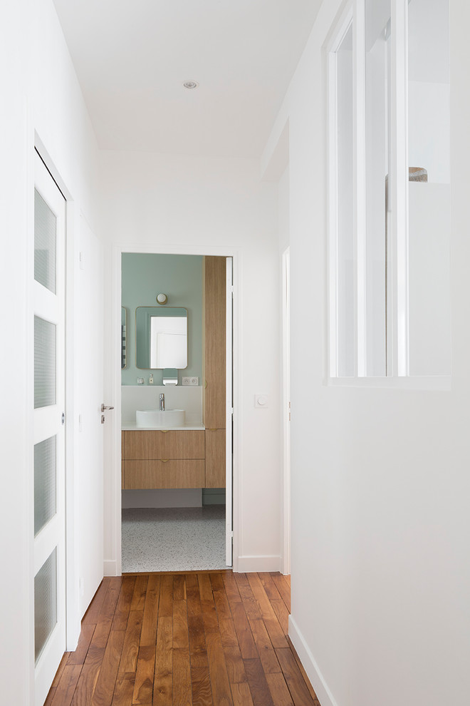 Idées déco pour une entrée contemporaine de taille moyenne avec un couloir, un mur blanc et un sol en bois brun.