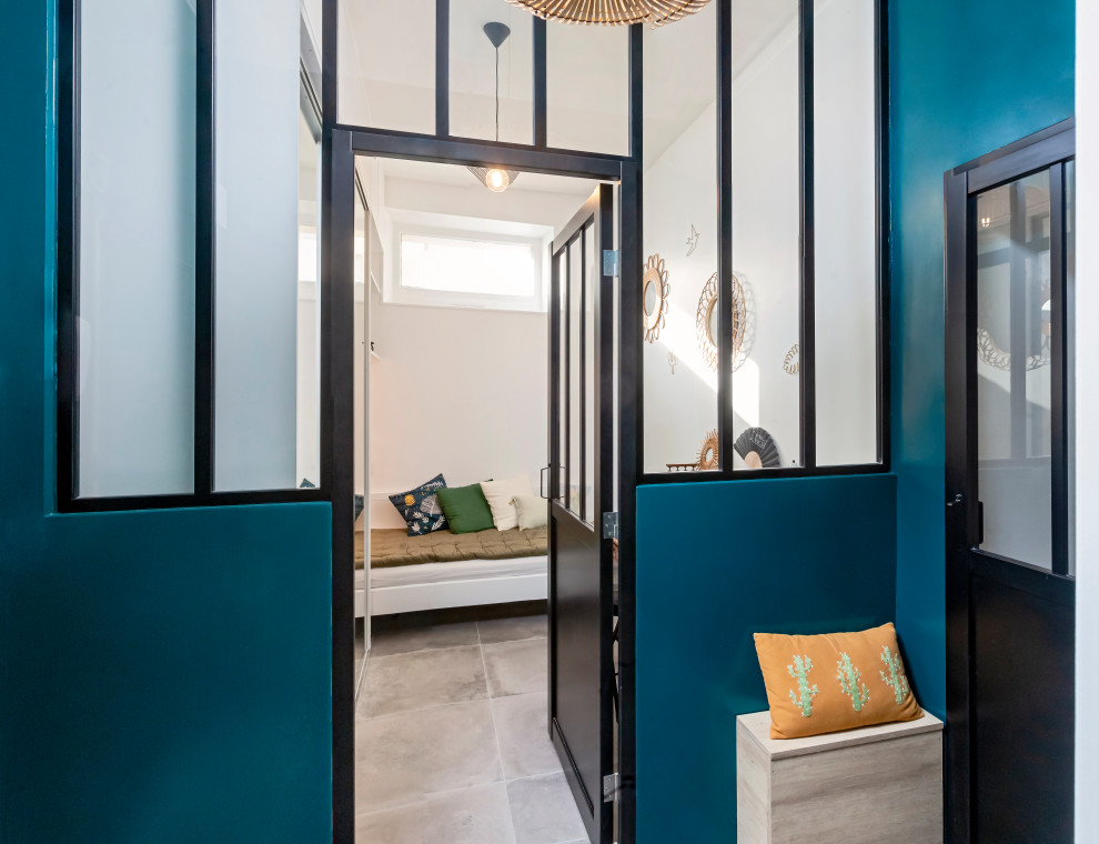 This is an example of a small modern foyer in Lyon with green walls, ceramic flooring, a single front door, a green front door and grey floors.