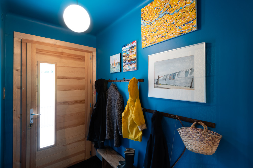 Modelo de puerta principal vintage pequeña con paredes azules, suelo de baldosas de cerámica, puerta simple, puerta de madera clara, suelo gris, papel pintado y papel pintado