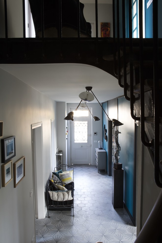 На фото: фойе среднего размера в стиле фьюжн с синими стенами, бетонным полом и серым полом