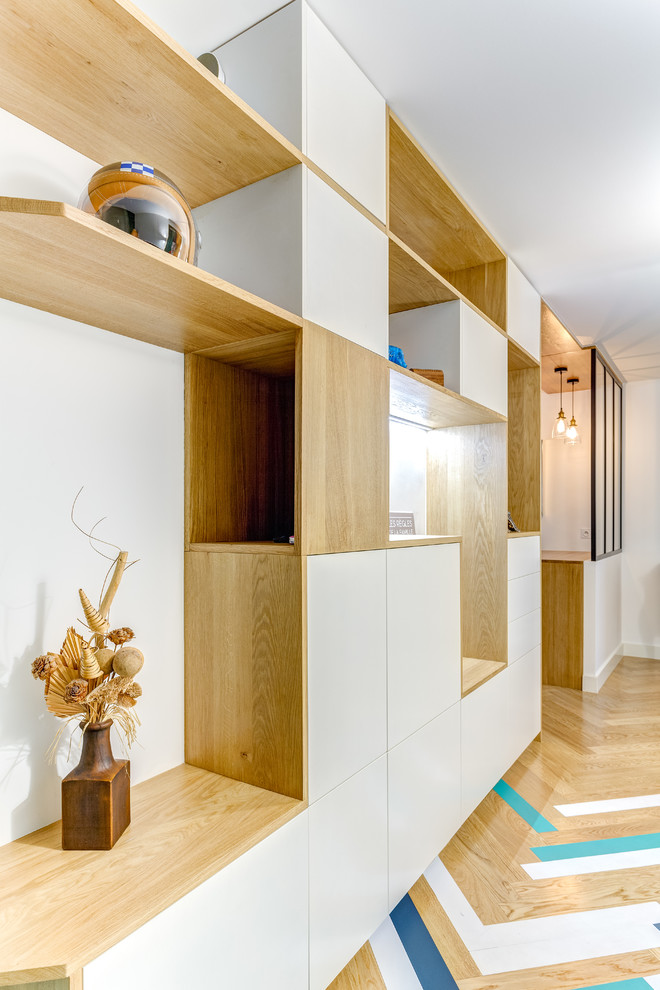 Diseño de distribuidor nórdico de tamaño medio con paredes blancas, suelo de madera clara, puerta simple, puerta azul y suelo multicolor