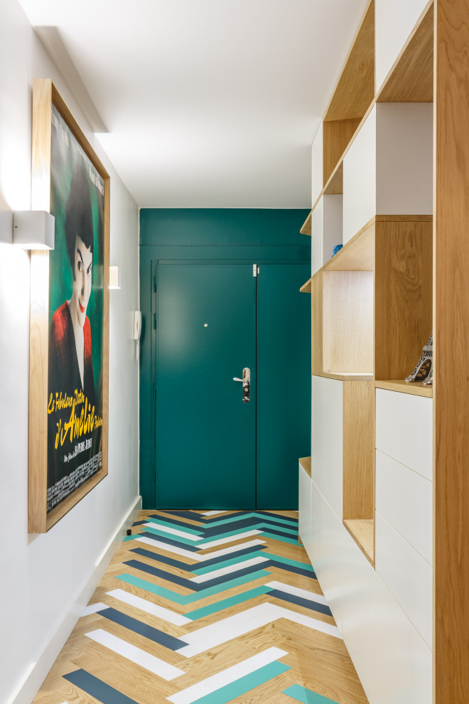 Cette image montre une entrée design avec un mur blanc, parquet peint, une porte simple, une porte verte et un sol multicolore.