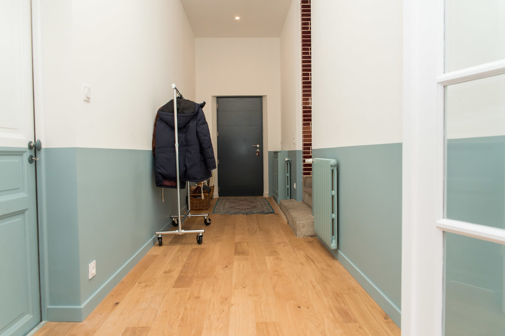 Idee per un corridoio classico di medie dimensioni con pareti verdi, parquet chiaro, una porta grigia e pavimento marrone