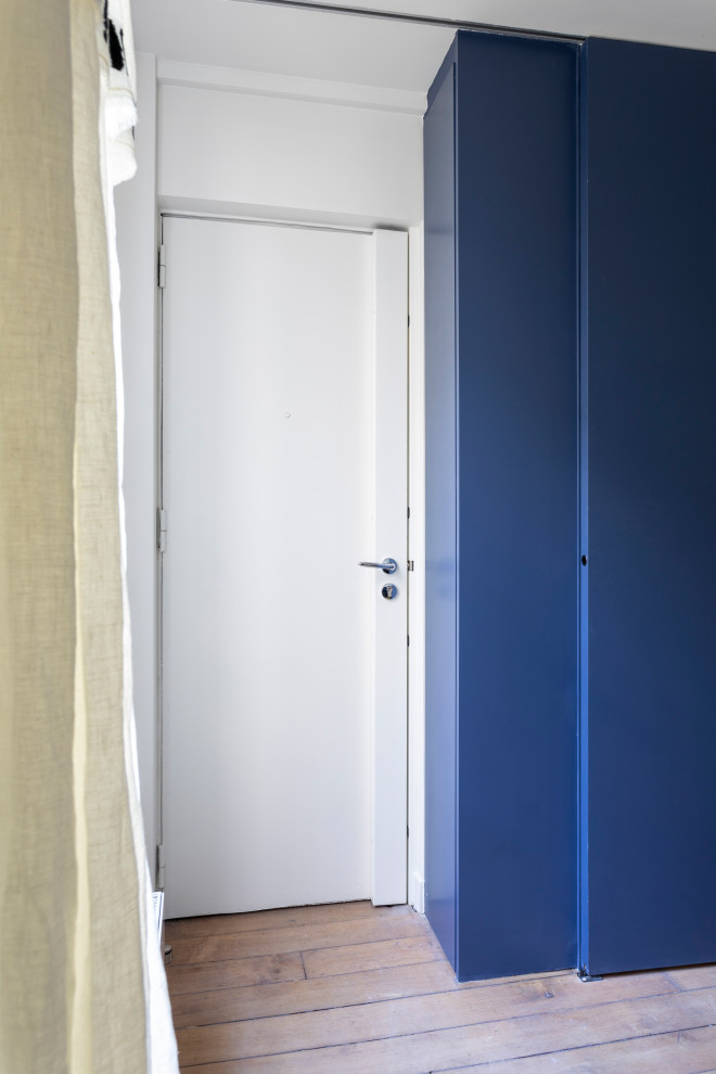 Пример оригинального дизайна: маленькая входная дверь в современном стиле с синими стенами, светлым паркетным полом, одностворчатой входной дверью, белой входной дверью, коричневым полом и многоуровневым потолком для на участке и в саду
