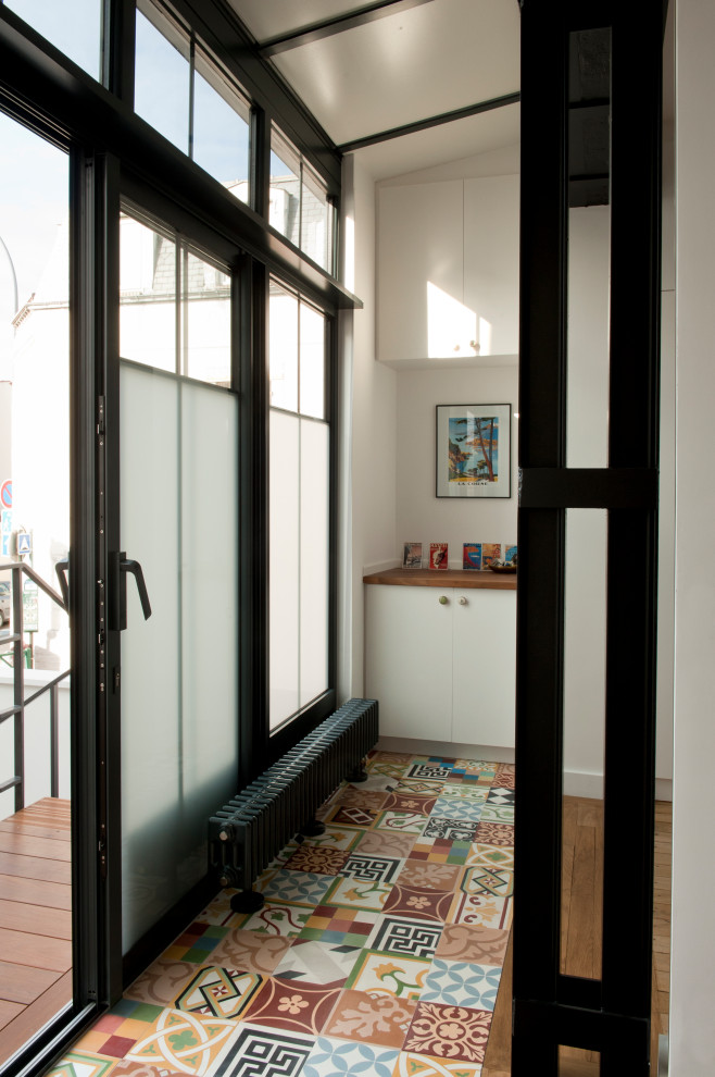 Inspiration for a mid-sized modern ceramic tile and multicolored floor entryway remodel in Other with white walls