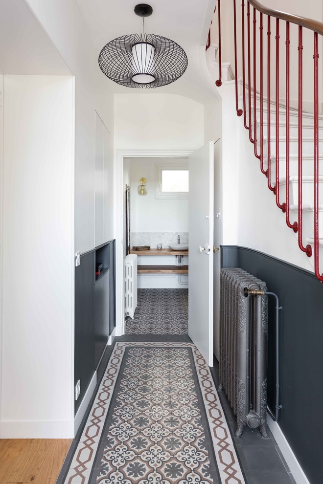 This is an example of a contemporary hallway in Paris with white walls and multi-coloured floors.