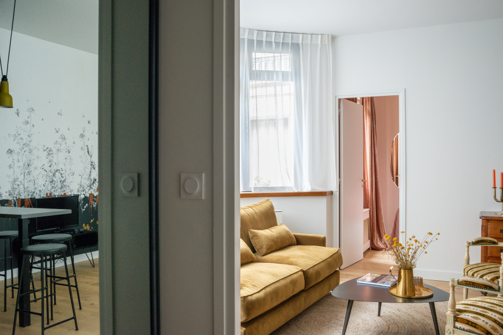 Cette photo montre une petite entrée tendance avec un vestiaire, un mur beige, parquet clair, une porte simple, une porte blanche et un sol beige.