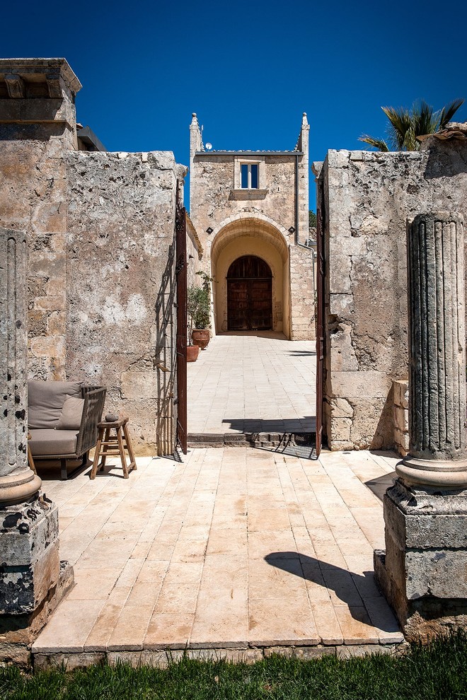 Immagine di una porta d'ingresso mediterranea di medie dimensioni con pavimento in terracotta, una porta a due ante, una porta in legno scuro e pavimento beige