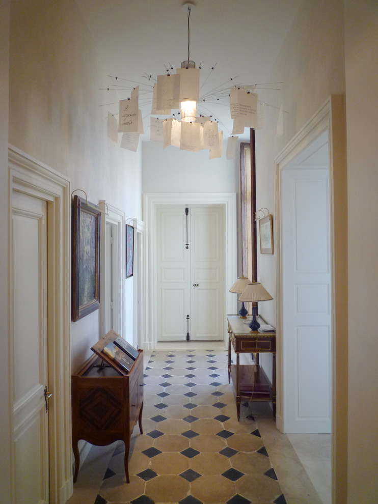 Aménagement d'une entrée contemporaine de taille moyenne avec un couloir et un mur blanc.