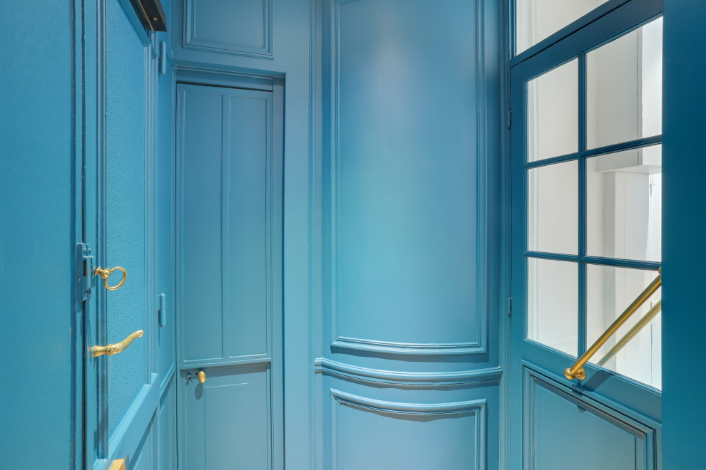 Aménagement d'un hall d'entrée de taille moyenne avec un mur bleu, parquet clair, une porte double, une porte bleue et un sol beige.