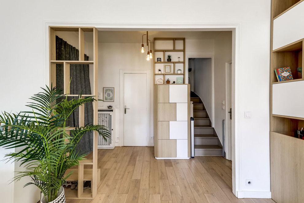 This is an example of a medium sized scandinavian foyer in Paris with white walls, light hardwood flooring and a double front door.