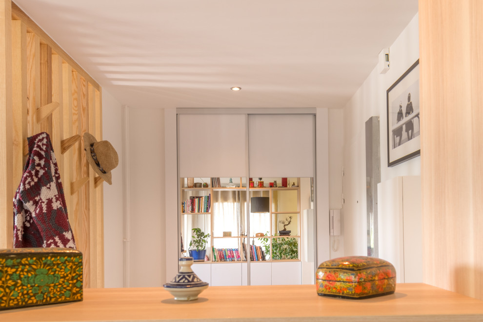 リヨンにあるお手頃価格の小さな北欧スタイルのおしゃれな玄関ロビー (白い壁、セラミックタイルの床、白いドア、ベージュの床) の写真
