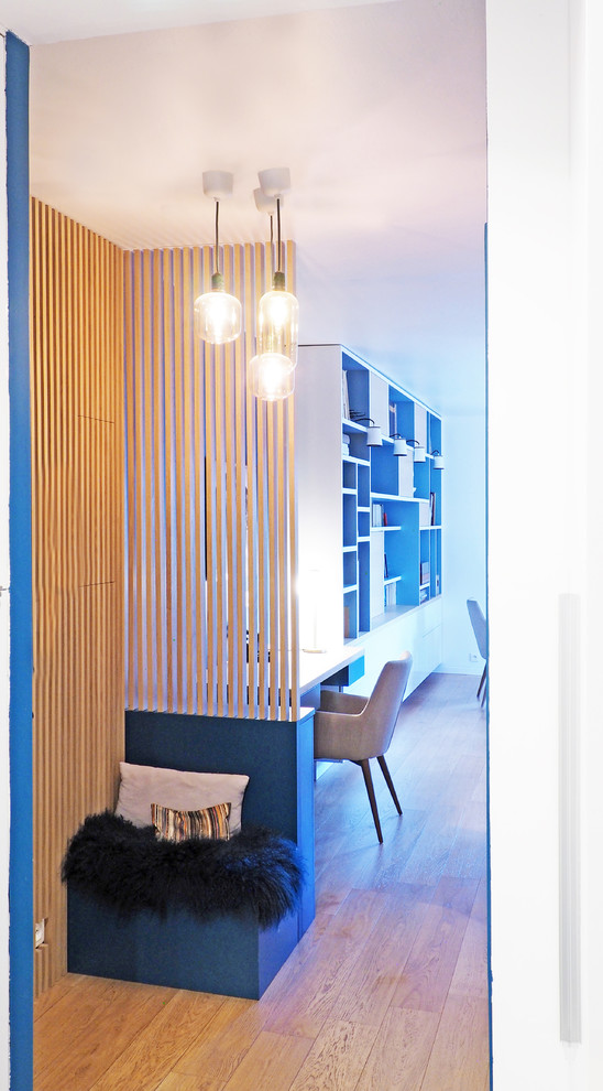 Idées déco pour une porte d'entrée contemporaine de taille moyenne avec un mur bleu, parquet clair, un sol marron, une porte simple et une porte bleue.