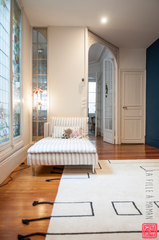 Ispirazione per un ampio ingresso minimal con pareti blu, parquet chiaro, una porta a pivot e una porta bianca