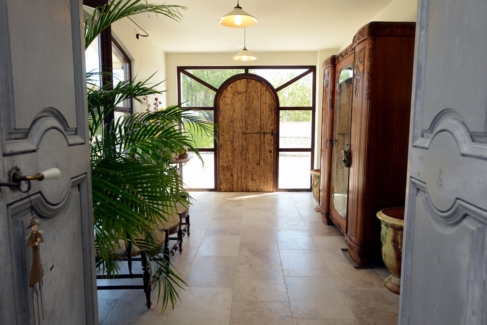 Bild på en stor eklektisk ingång och ytterdörr, med beige väggar, travertin golv, en enkeldörr, mörk trädörr och beiget golv