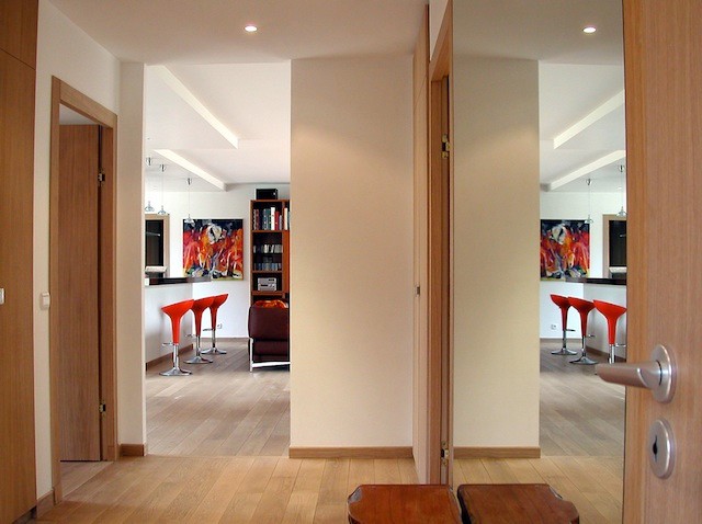 Inspiration pour un vestibule minimaliste de taille moyenne avec un mur blanc, parquet clair et une porte en verre.