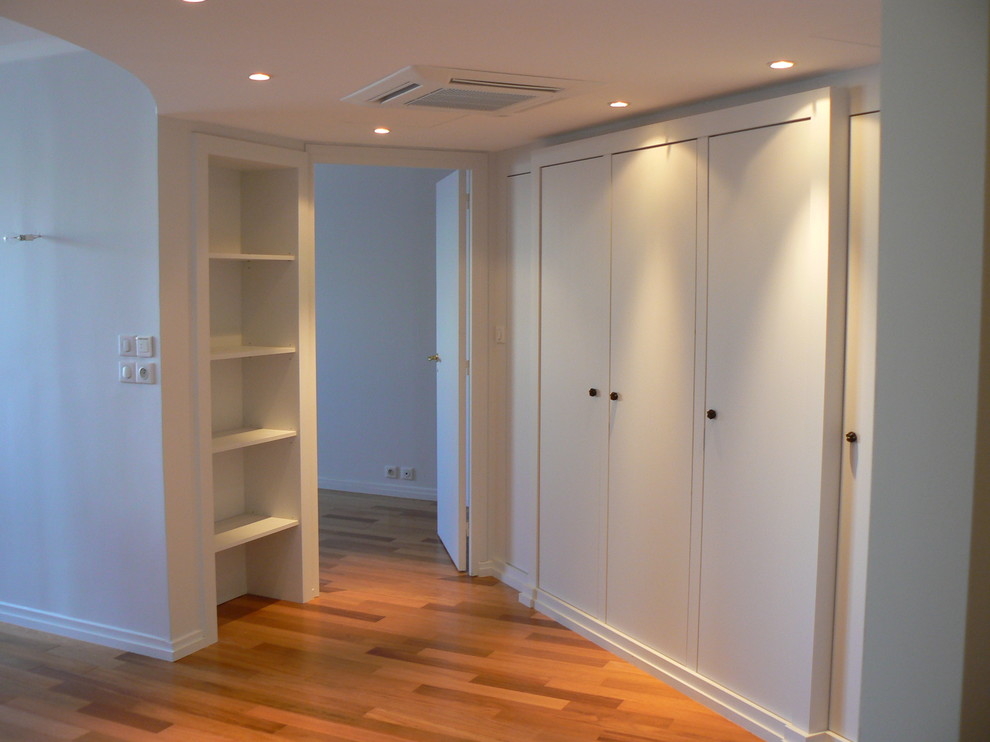 Immagine di un grande ingresso o corridoio minimal con pareti bianche e pavimento in legno massello medio