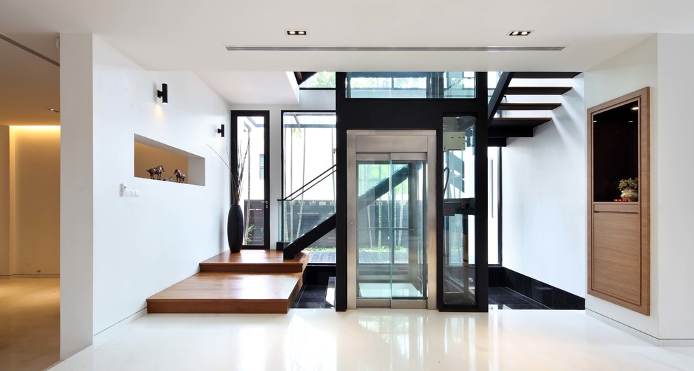 Example of a trendy white floor entryway design in Singapore with white walls