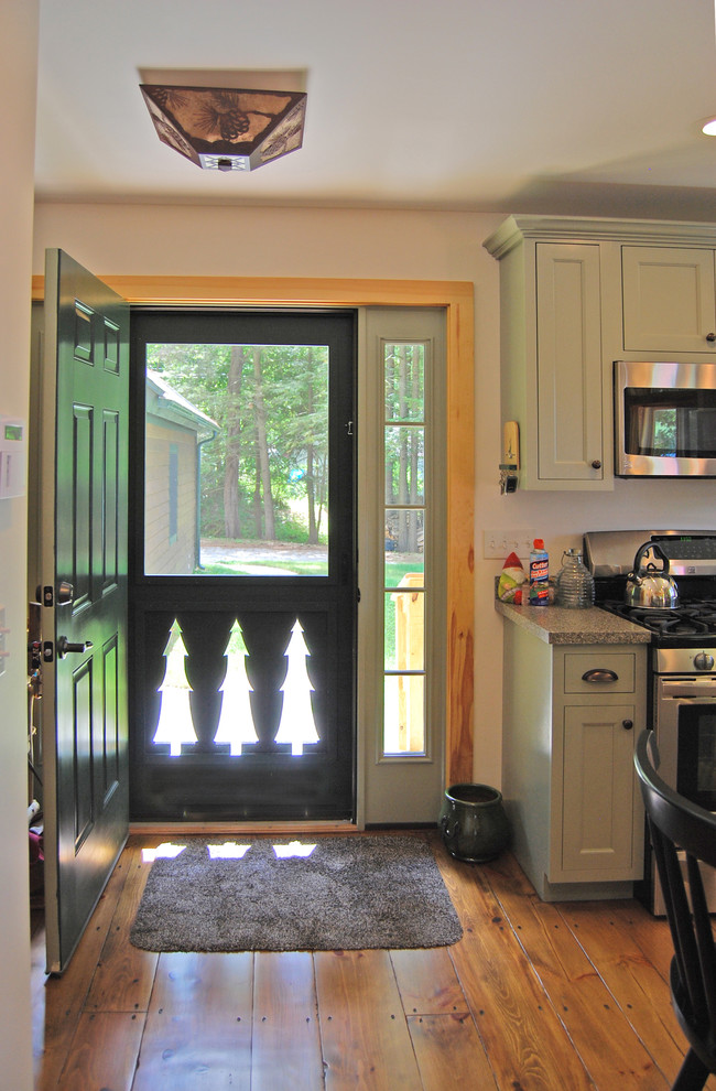 Cette photo montre une entrée chic de taille moyenne avec un sol en bois brun, une porte simple et une porte verte.