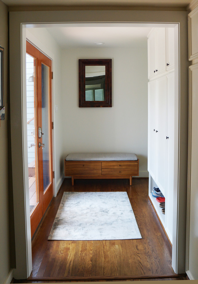 Immagine di un ingresso con anticamera minimalista di medie dimensioni con pareti bianche, parquet scuro, una porta a due ante, una porta in vetro e pavimento marrone