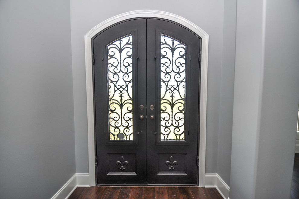 Esempio di un ingresso tradizionale di medie dimensioni con pareti grigie, parquet scuro, una porta a due ante e una porta in legno scuro