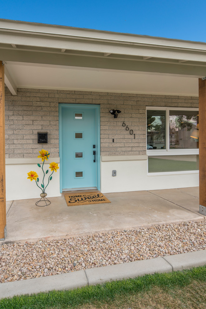 Example of a mid-century modern entryway design in Phoenix with a blue front door